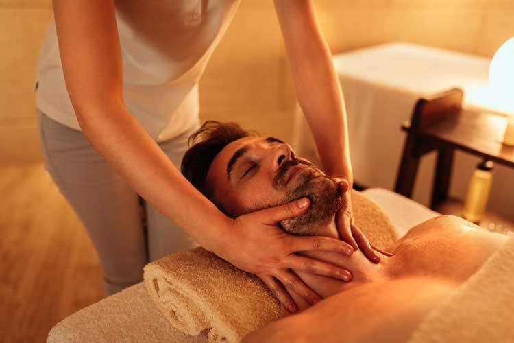 a woman receiving a facial massage in a salon