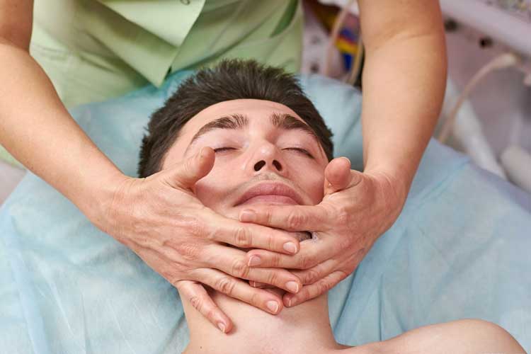 a woman receiving a facial massage in a salon